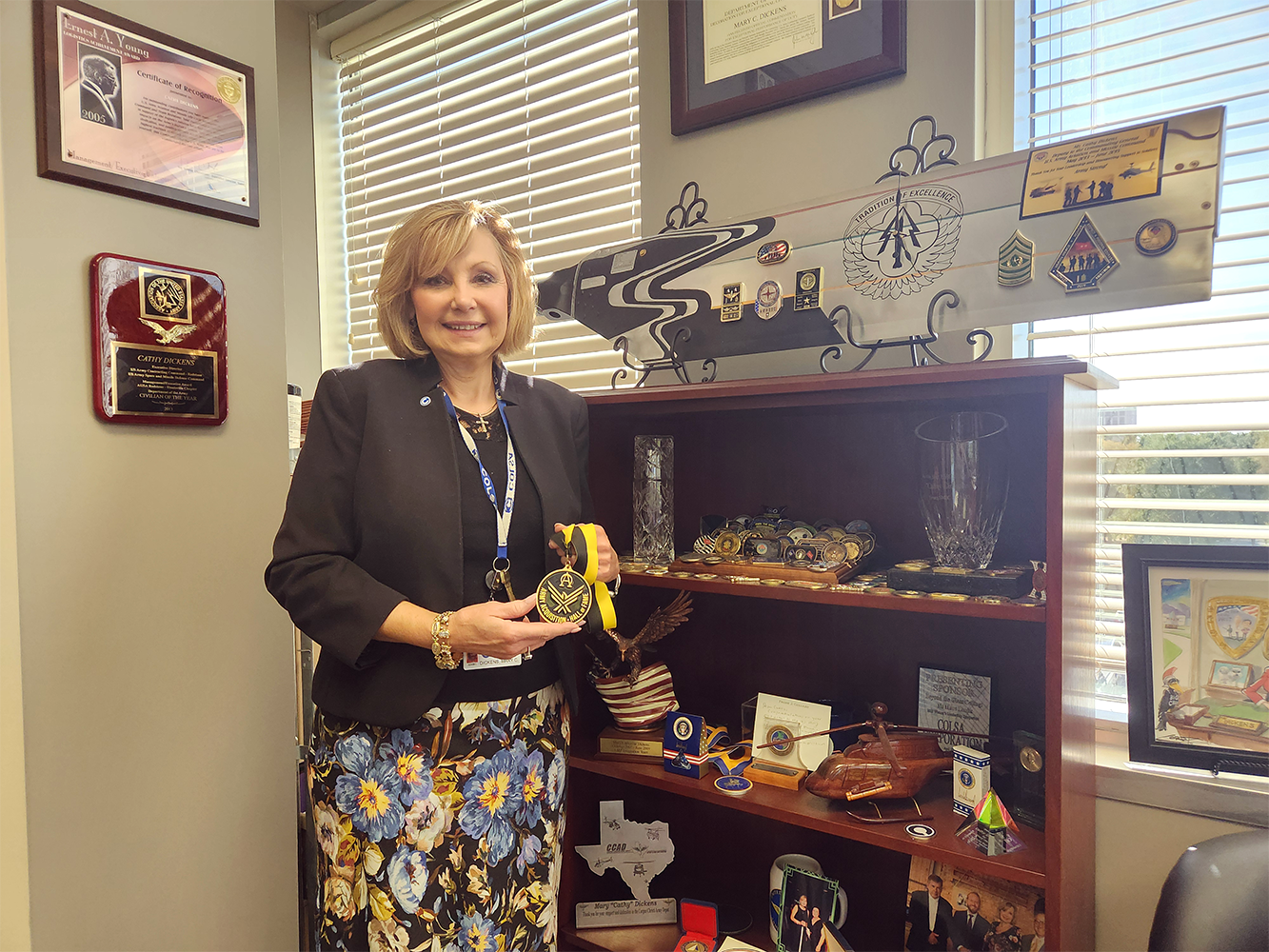 Ms. Cathy Dickens and her collection of awards.